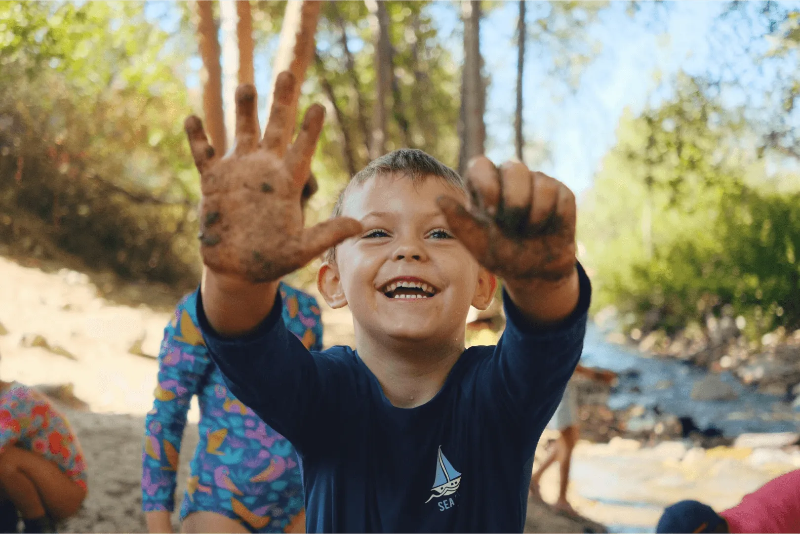 child smiling outdoors nature exploration program